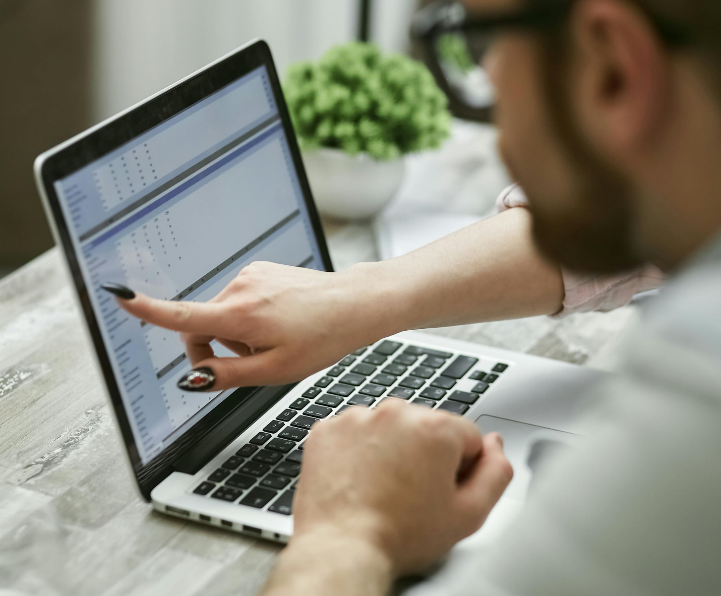 person pointing finger to a laptop screen